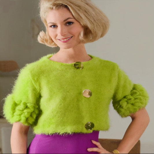 Woman wearing a bright green fuzzy cardigan with gold buttons against a neutral background