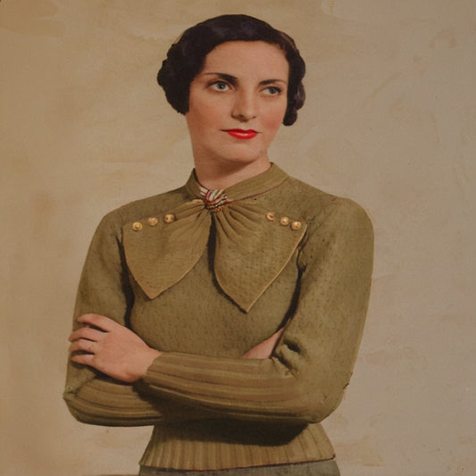 Woman wearing a vintage olive green sweater with a bow neckline against a beige background