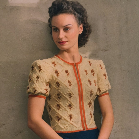 Woman wearing a vintage-style cardigan with floral patterns against a plain background