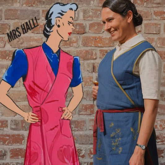 Woman in a blue apron standing next to a cartoon depiction of 'Mrs Hall' against a brick wall.