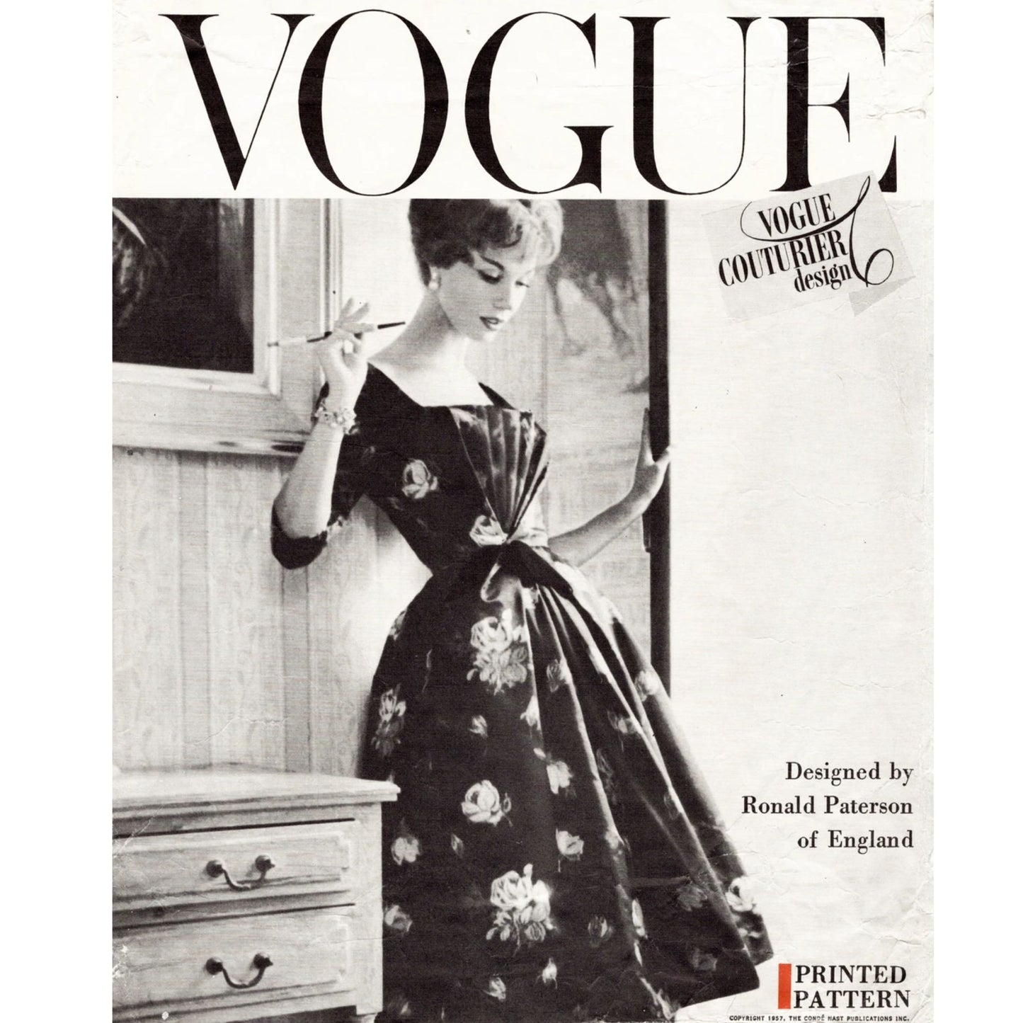 Vintage Vogue magazine cover with a woman in a floral dress holding a fan.