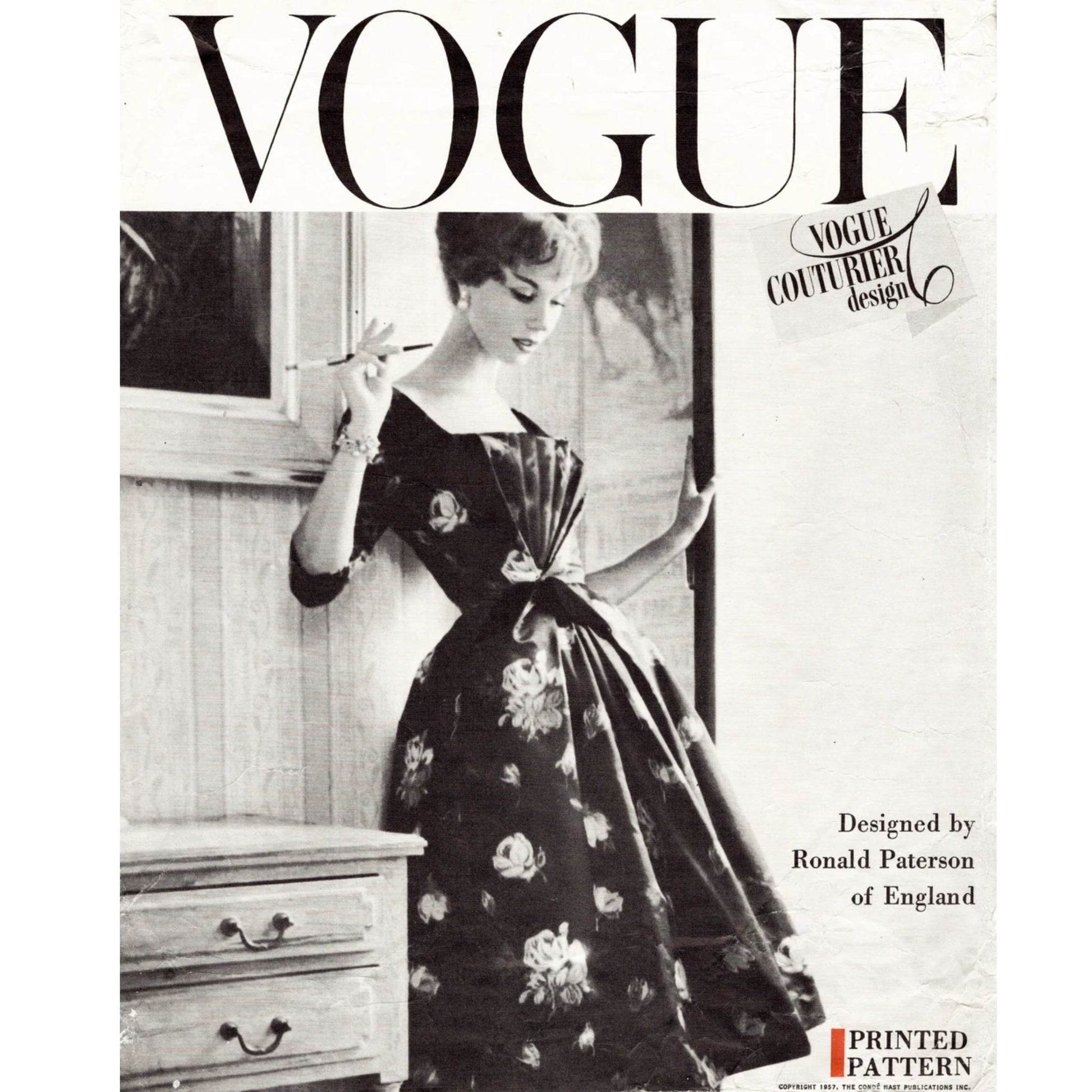 Vintage Vogue magazine cover with a woman in a floral dress holding a fan.