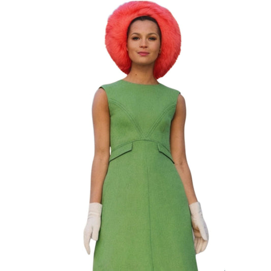 Person wearing a green dress with a red hat on a white background
