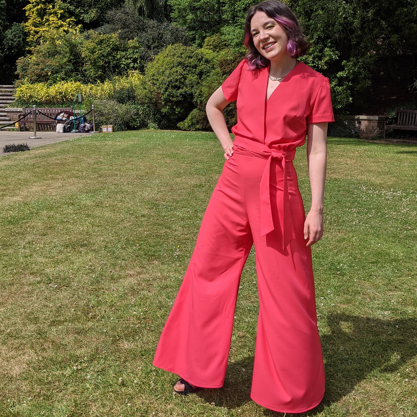 Women wearing white palazzo pants and wrap around blouse.