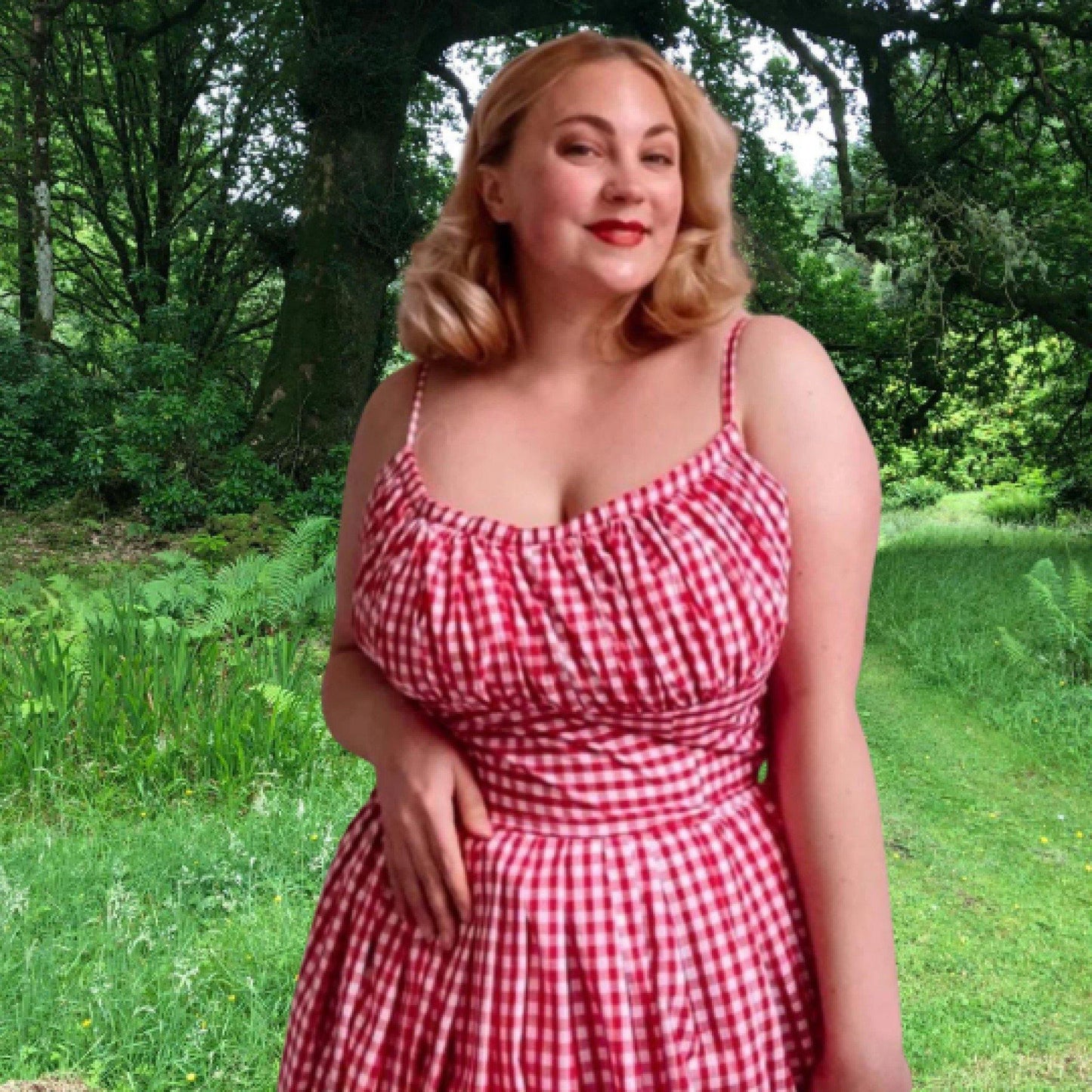 Close up photograph of a women wearing the 'Marilyn' bombshell dress in red gingham.