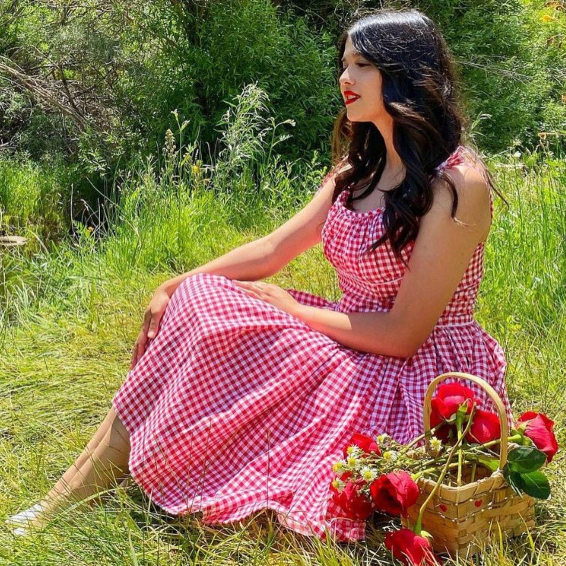 Women sat down wearing 'Marilyn' bombshell dress in red gingham.